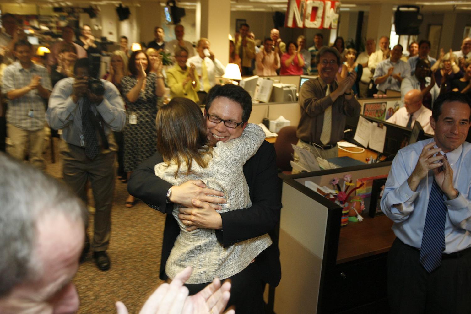 PolitiFact Founder Bill Adair receives congratulations from Reporter and Researcher Angie Drobnic Holan in the newsroom of the St. Petersburg Times.