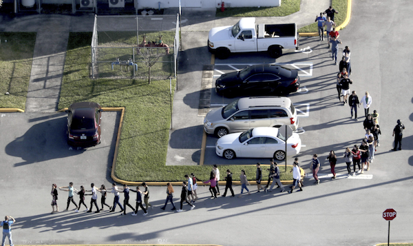 Students are evacuated by police from Marjorie Stoneman Douglas High School in Parkland, Fla., on Wednesday, Feb. 14, 2018, after a shooter opened fire on the campus. (Mike Stocker | South Florida Sun-Sentinel via AP)