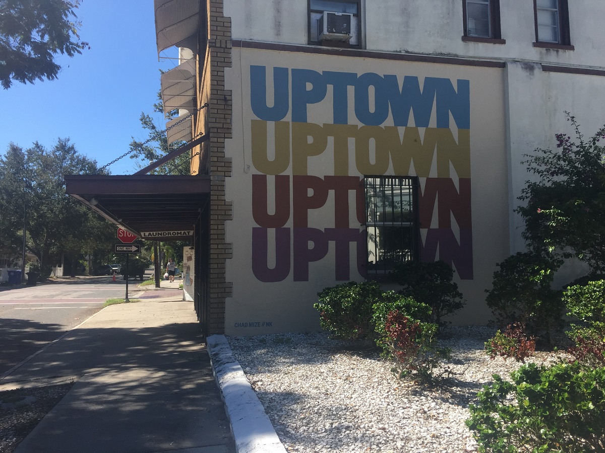 A sprawling geometric mural and a new insignia with the word “Uptown” can be seen on the sides of the building that houses the Uptown Laundromat. (Photo by Allison Graves)